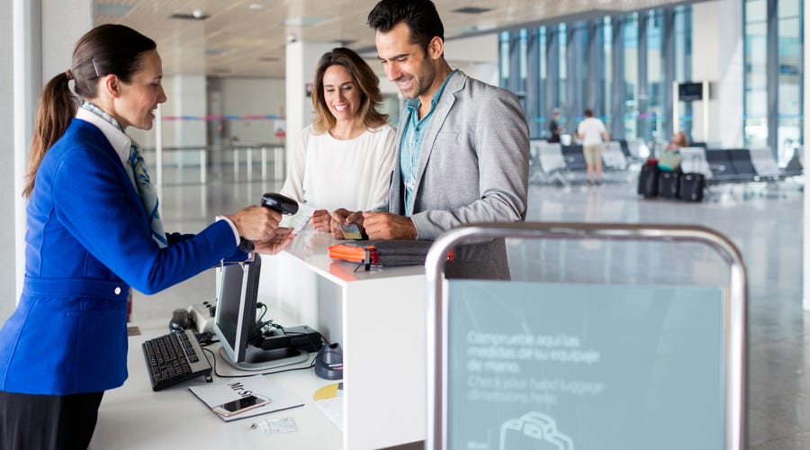 Ein Pärchen steht am Flughafen und checkt ein