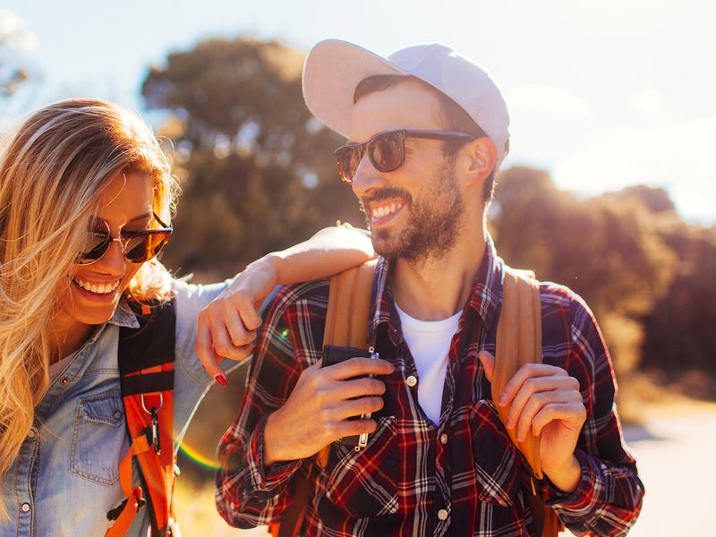 Ein Mann und eine Frau sind draußen unterwegs und lachen.