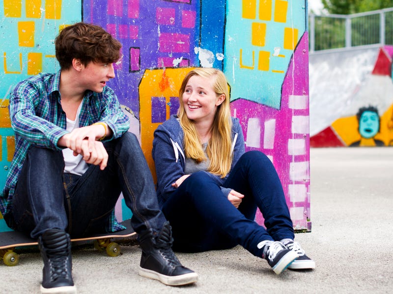 Zwei Jugendliche sitzen zusammen und unterhalten sich