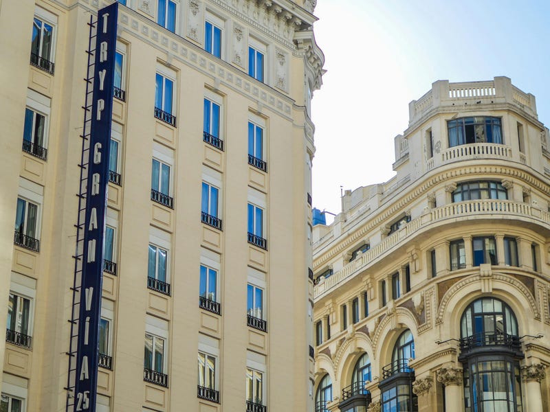 Zwei helle, typisch spanische und prunkvolle Gebäude vor blauem Himmel