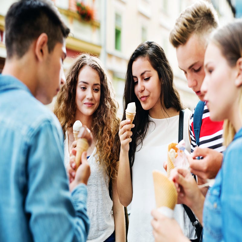 Mehrere Jugendliche stehen zusammen und essen Eis.