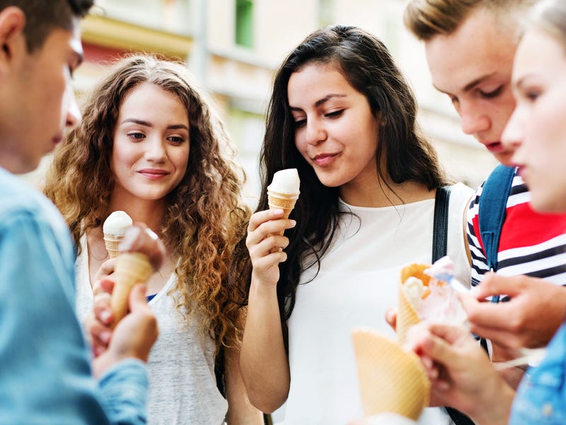 Mehrere Jugendliche stehen zusammen und essen Eis.