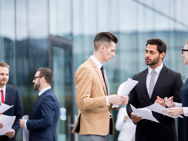 Mehrere Personen stehen zusammen und besprechen etwas.