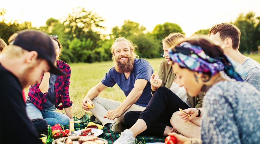 Gruppe von Menschen sitzt zusammen und isst