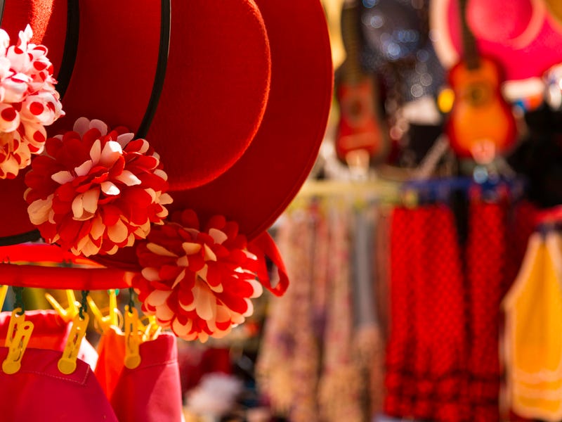Many hats and clothes hanging in a store.