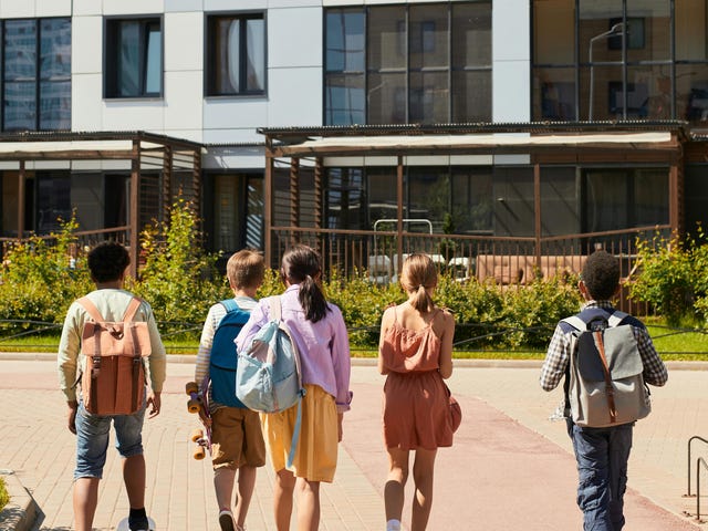 Mehrere Kinder im Sprachcamp sind mit Rucksäcken unterwegs bei einem Ausflug in die Umgebung.