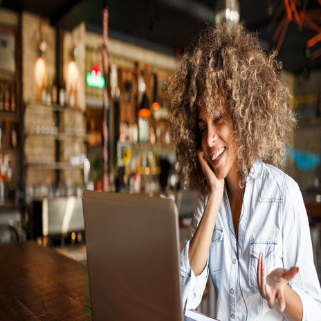 Eine Frau nimmt an einem Online-Sprachkurs in einem Café teil.