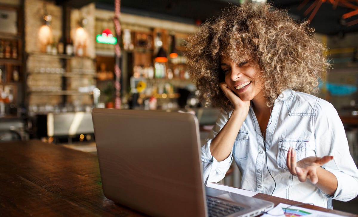 Eine Frau nimmt an einem Online-Sprachkurs in einem Café teil.