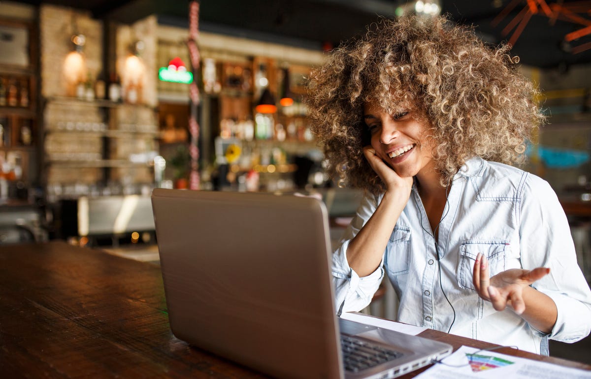 Eine Frau nimmt an einem Online-Sprachkurs in einem Café teil.