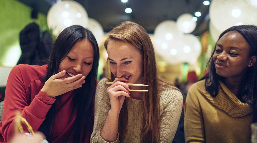 Drei Frauen essen gemeinsam japanisch.