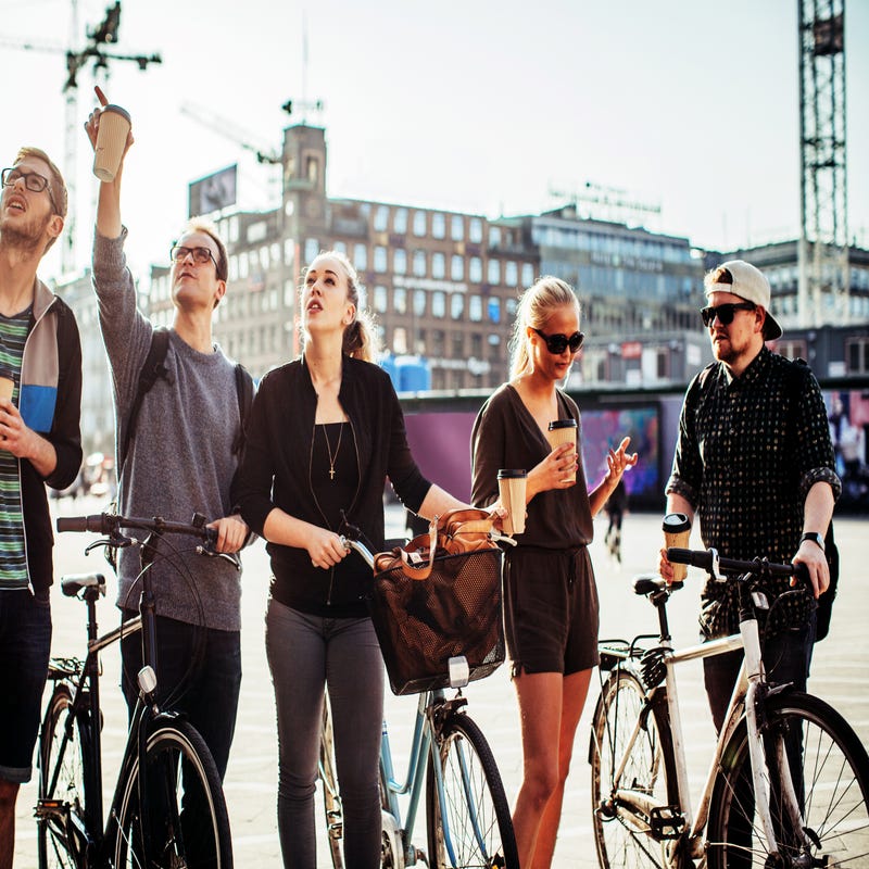 Mehrere Jugendliche sind mit Fahrrädern in der Stadt unterwegs.