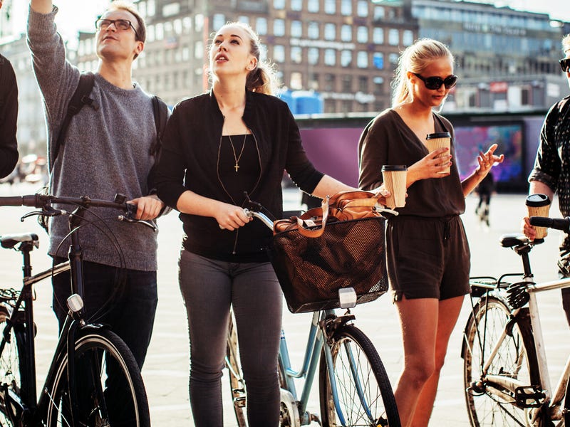 Mehrere Jugendliche sind mit Fahrrädern in der Stadt unterwegs.