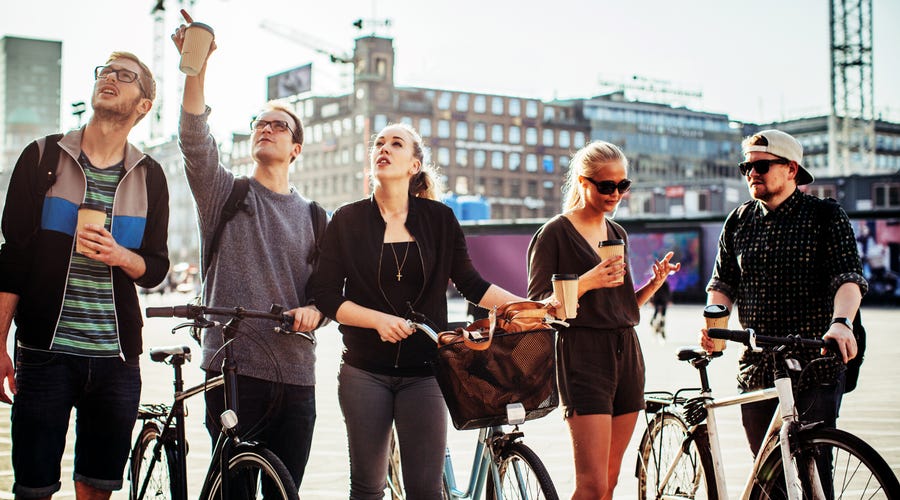 Mehrere Jugendliche sind mit Fahrrädern in der Stadt unterwegs.