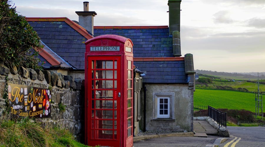 Eine Landschaft in Nordirland mit Haus und Telefonzelle.