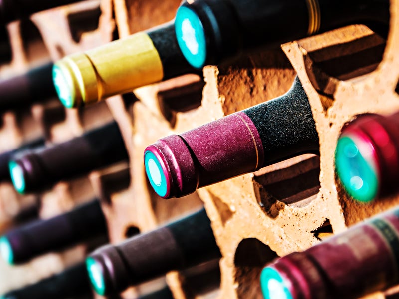 Weinflaschen lagern in einem Holzregal.