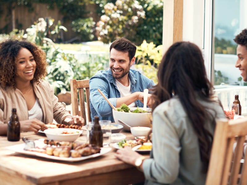 Mehrere Personen sitzen gemeinsam am Tisch, lachen und reden.