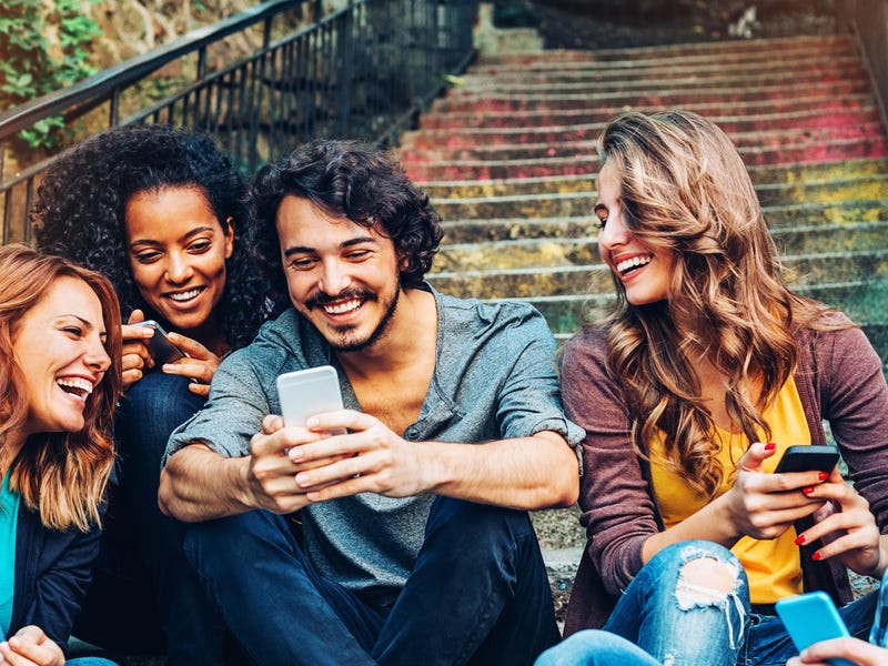 Gruppe Menschen schaut auf Smartphone.