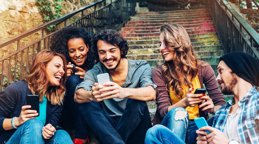 Gruppe Menschen schaut auf Smartphone.