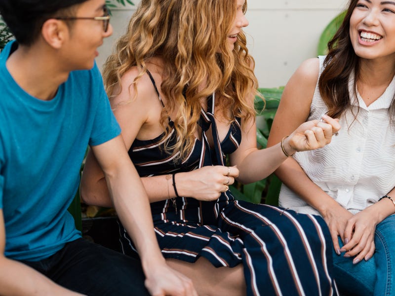 Drei junge Menschen unterhalten sich mit Gestik
