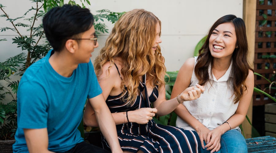 Drei junge Menschen unterhalten sich mit Gestik