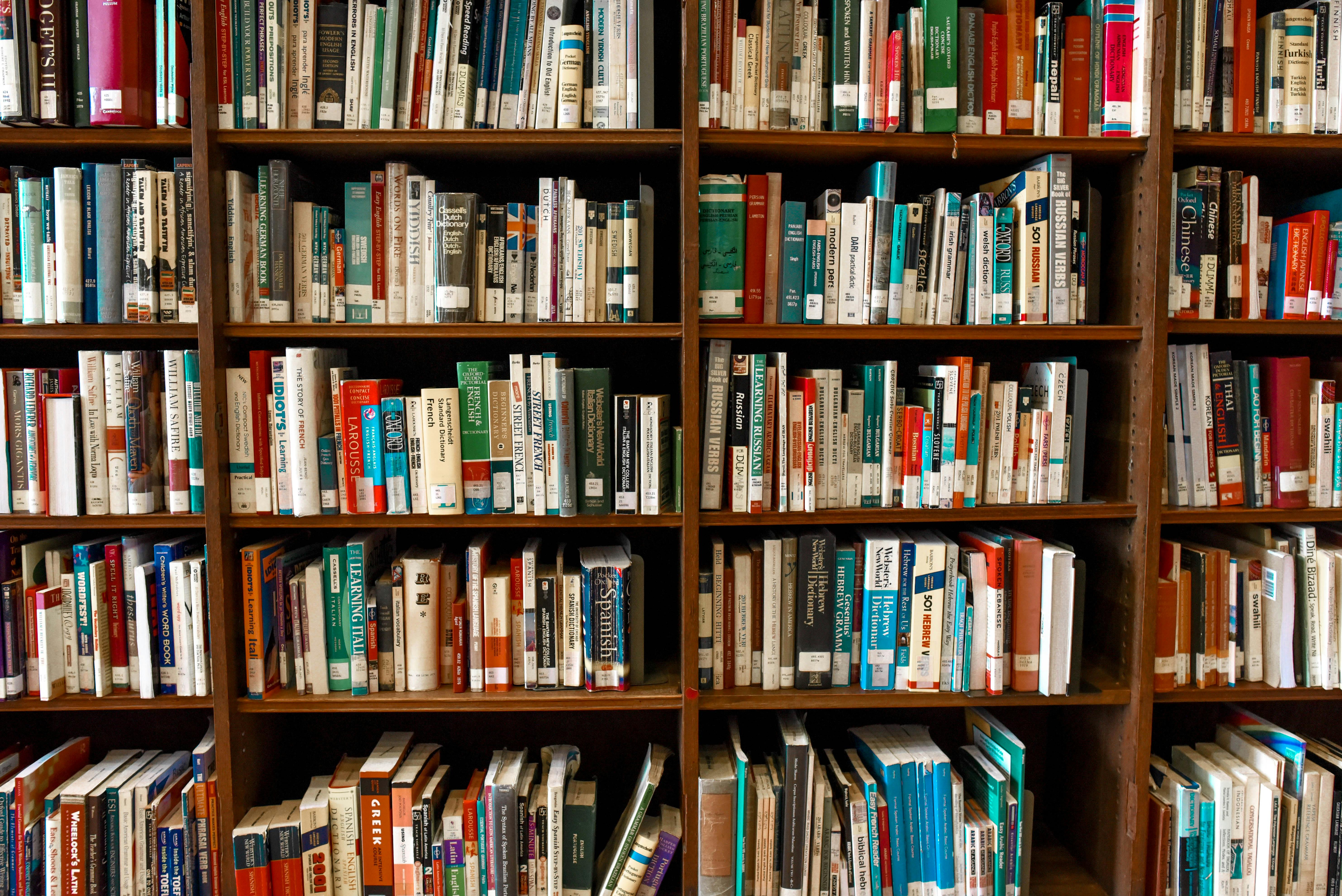 braunes Bücherregal, gefüllt mit einer Vielzahl an Büchern