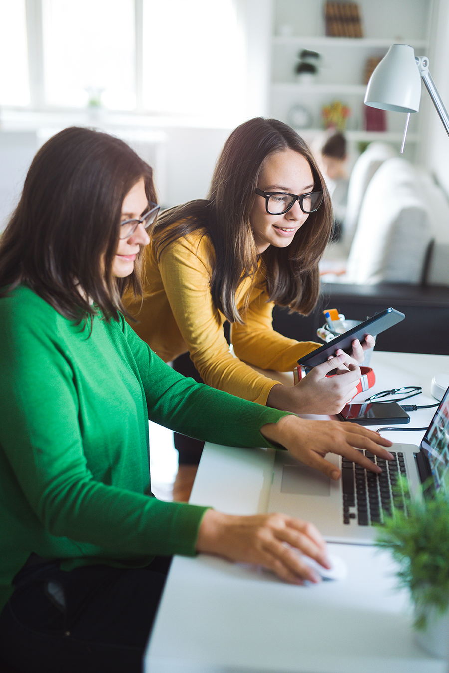 Mutter und Kind schauen gemeinsam auf einen Laptop.