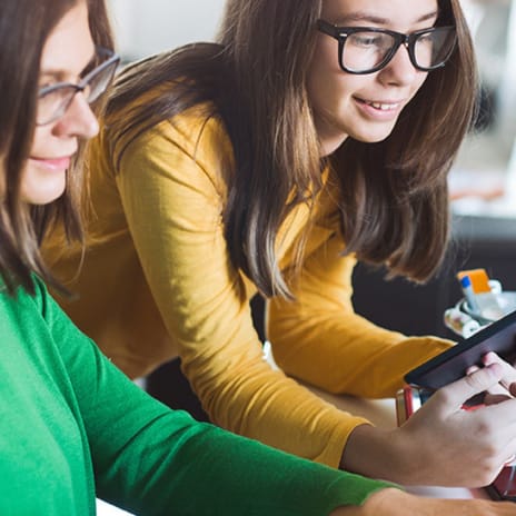 Mutter und Kind schauen gemeinsam auf einen Laptop.