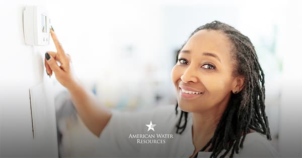 woman using her thermostat