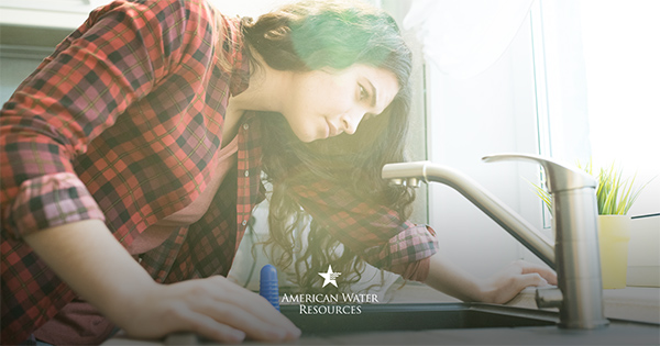 woman uses sink faucet