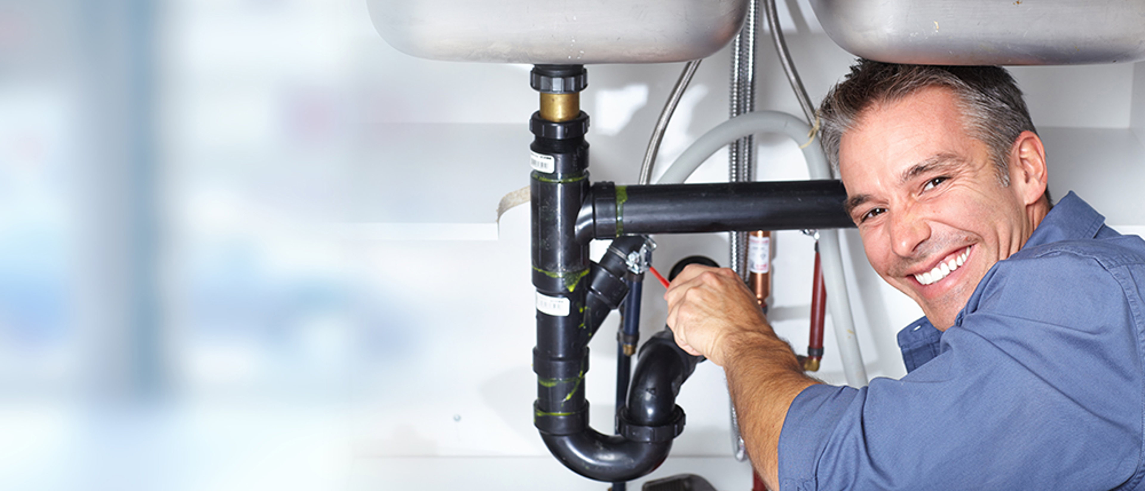 plumber working on sink pipe