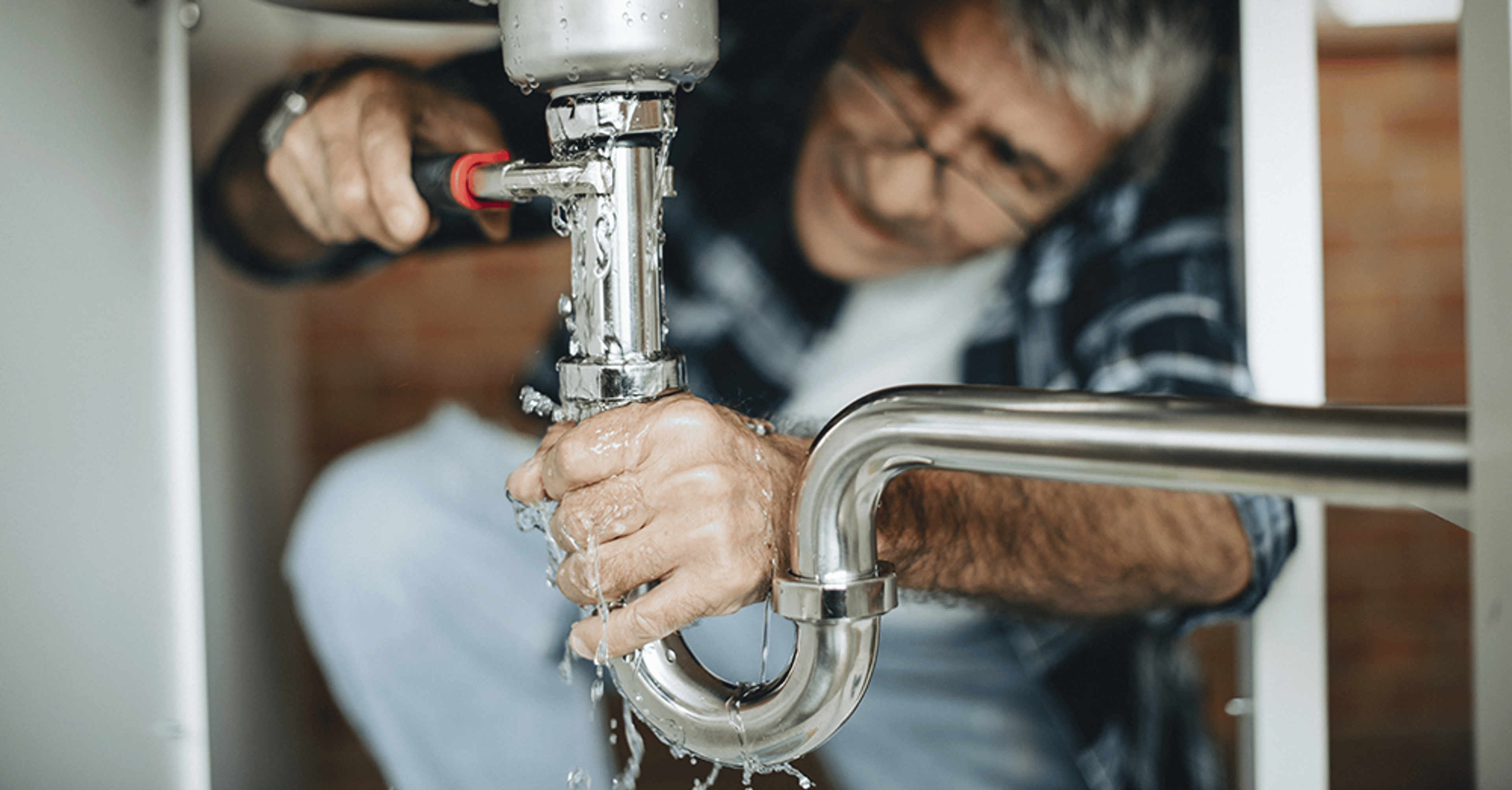 plumber fixing leaky pipe