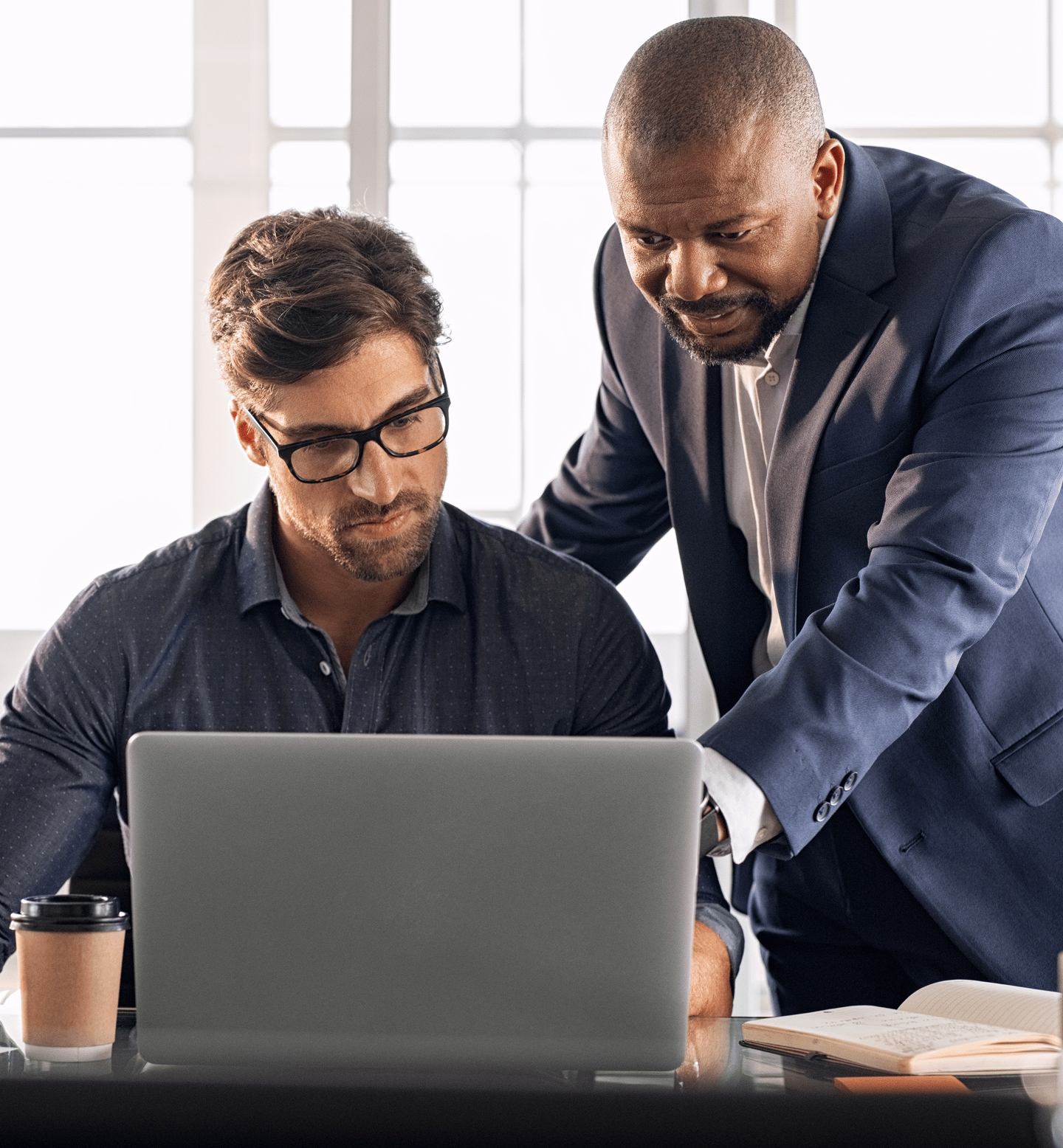 Two People Looking at Laptop While One Man Points