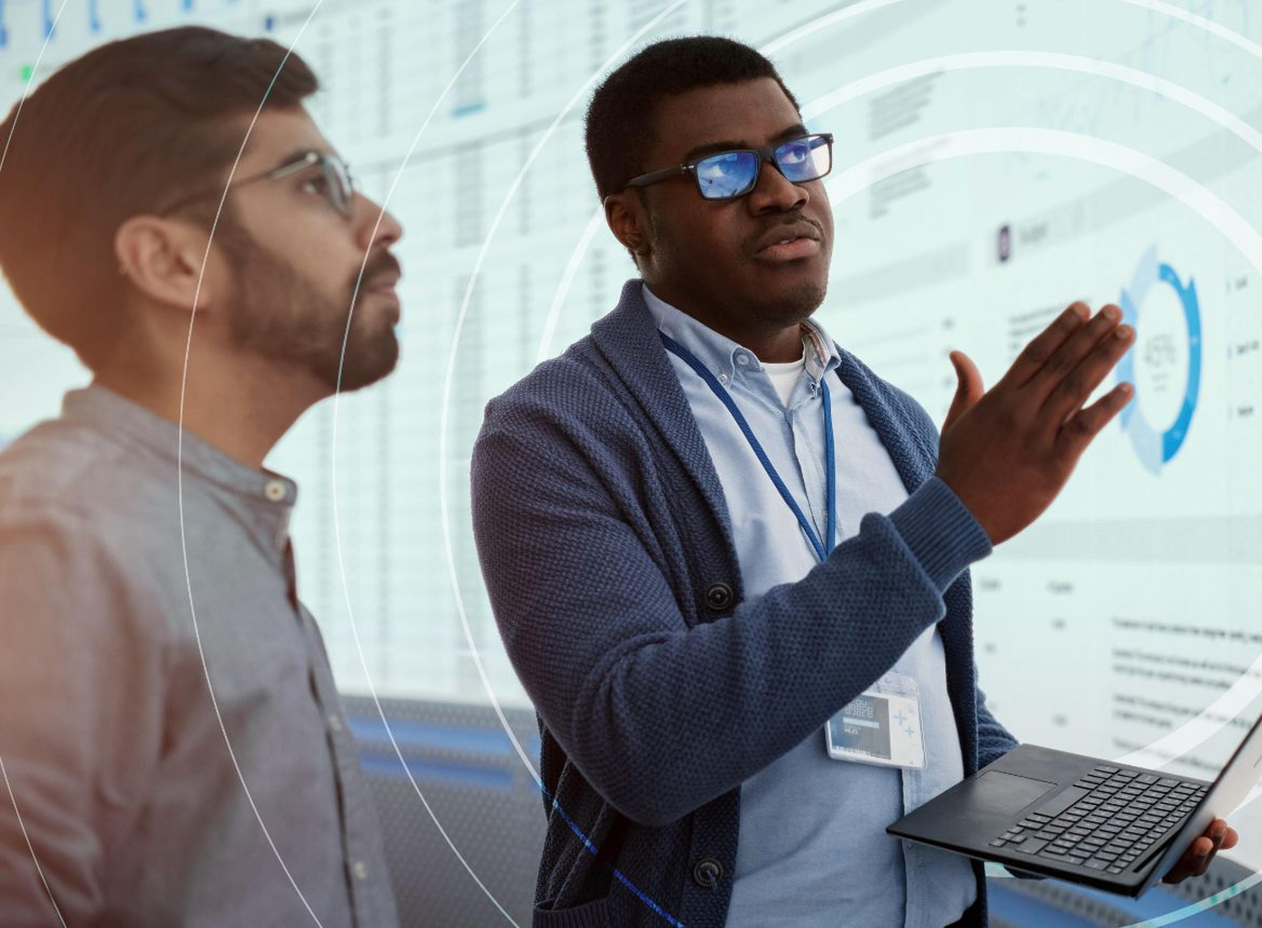 Two Men Talking and Look at a Screen