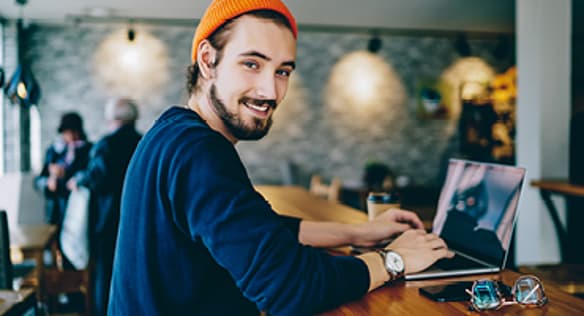Man Smiling and Using Laptop