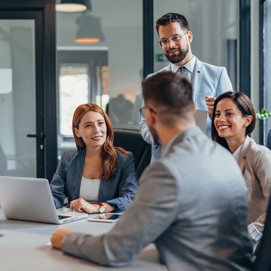 Four People at a Conference Table Smiling