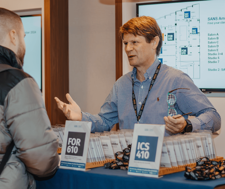 Man Talking to a Student at Registration Table