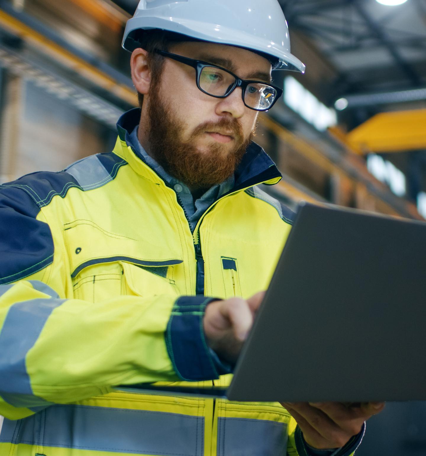  Man in High-Vis Jacket and Hardhat Looking at Tablet