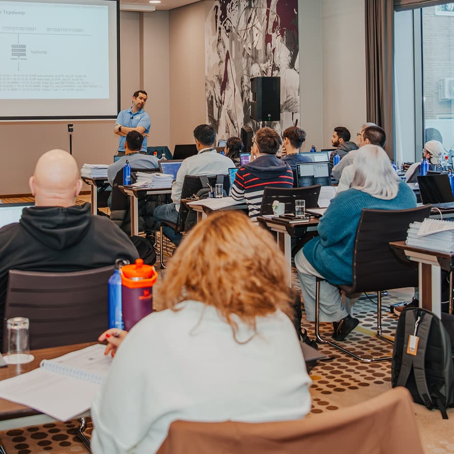 Teacher in Blue Shirt Standing in Front of Students in Classroom