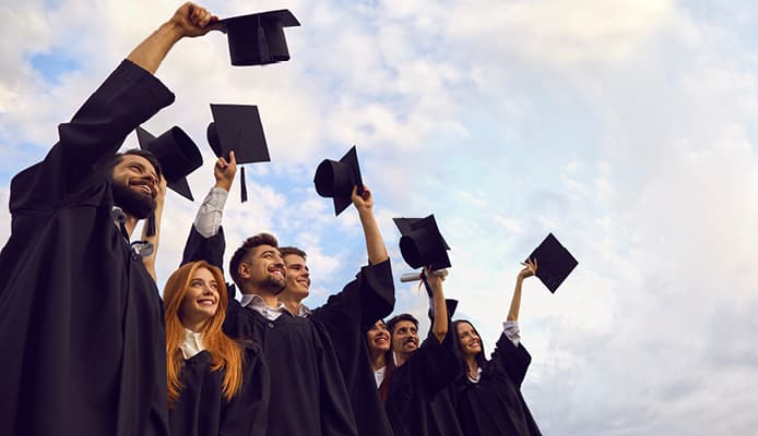 People Holding Up Graduation Caps