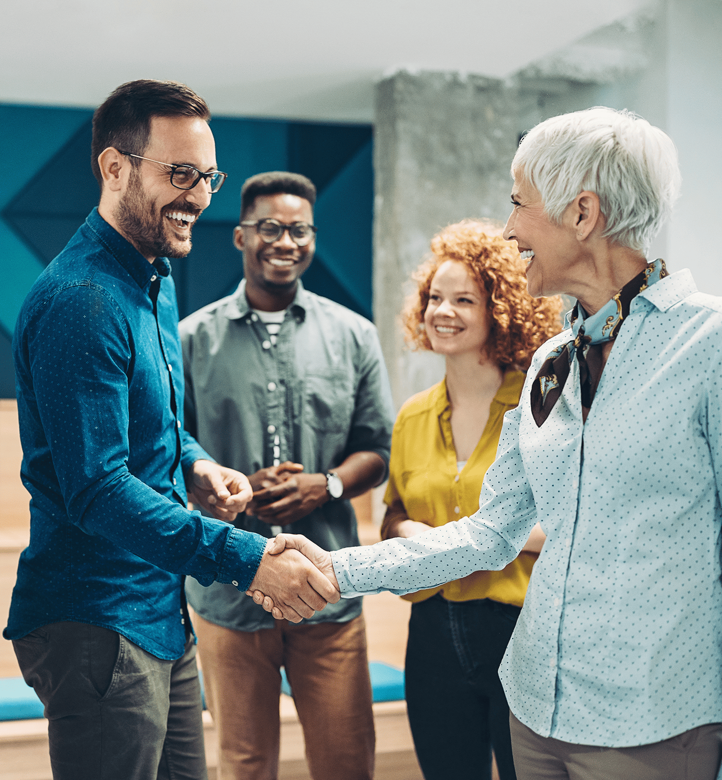 Two People Shaking Hands While Two Others Smile