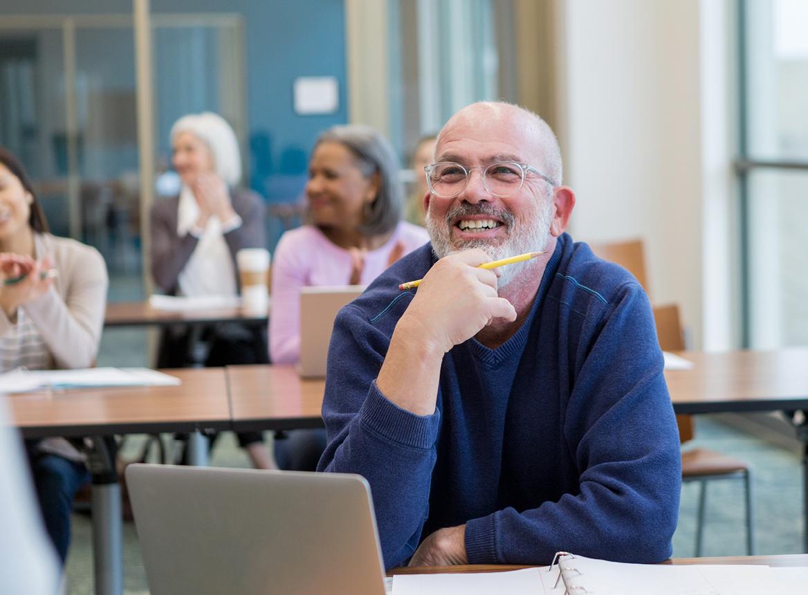 Classroom Setting with People Smiling as They Listen to a Lecture
