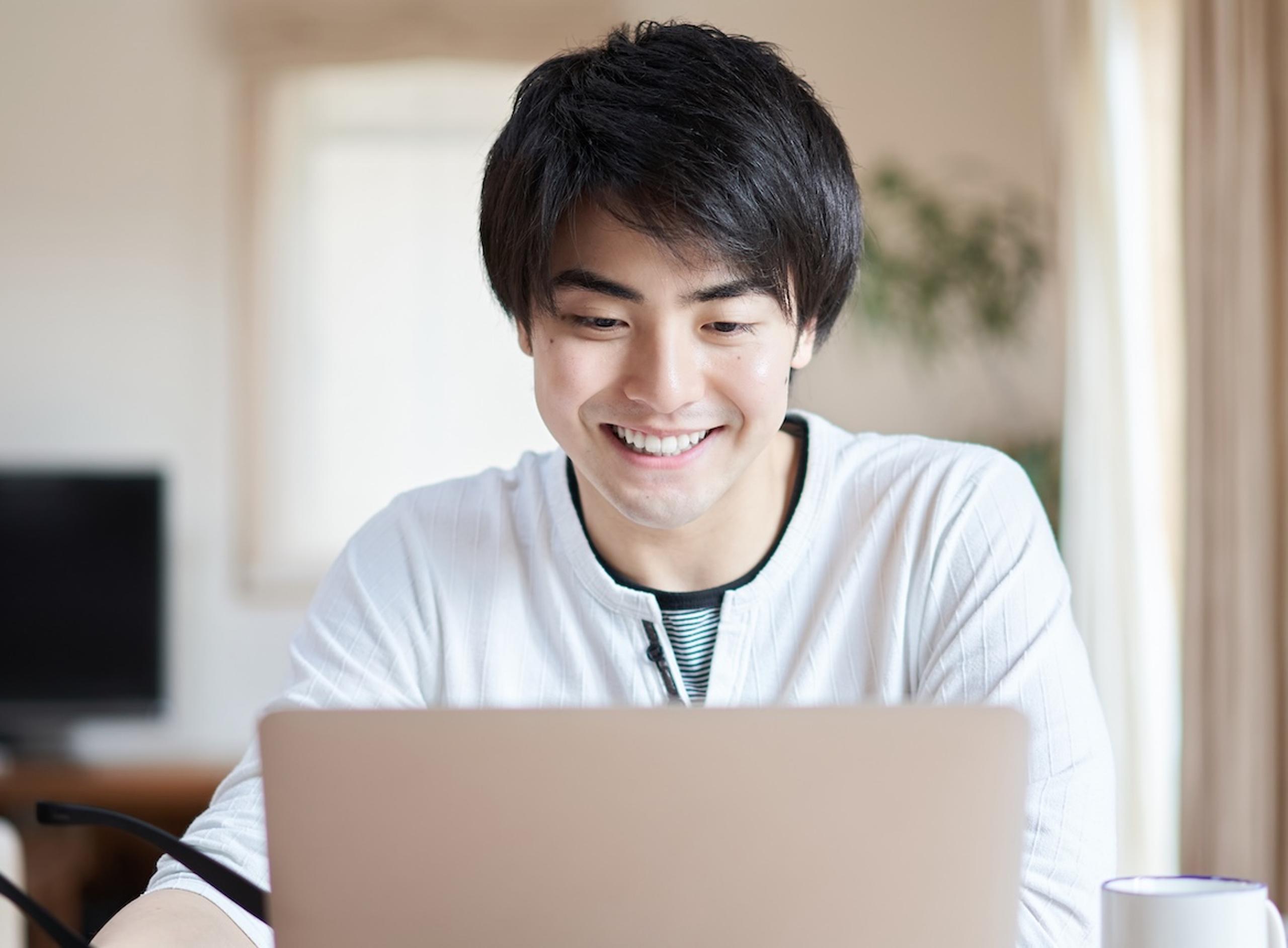 Asian Man Looking at Laptop