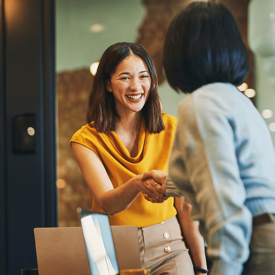 Two Women Shaking Hands in an Office