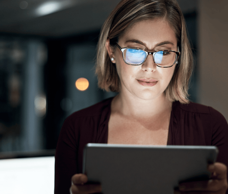 Woman looking at laptop in dim room