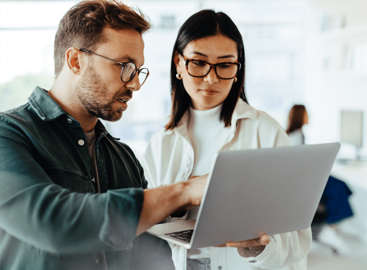 Two People Looking at a Laptop