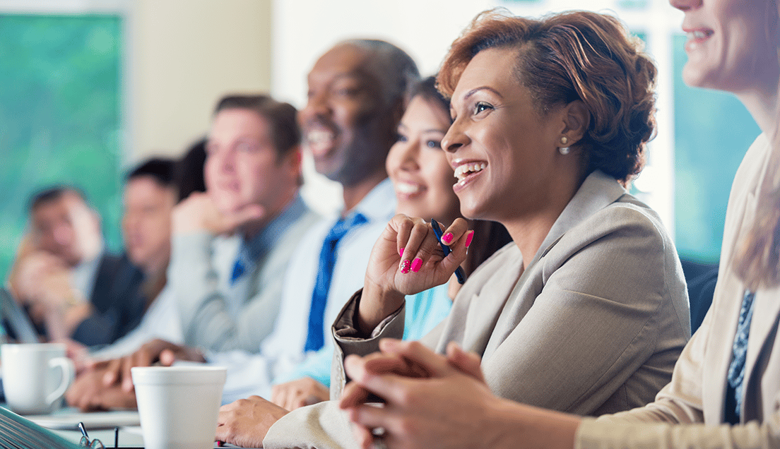 Several People Smiling and Listening to Someone Talk