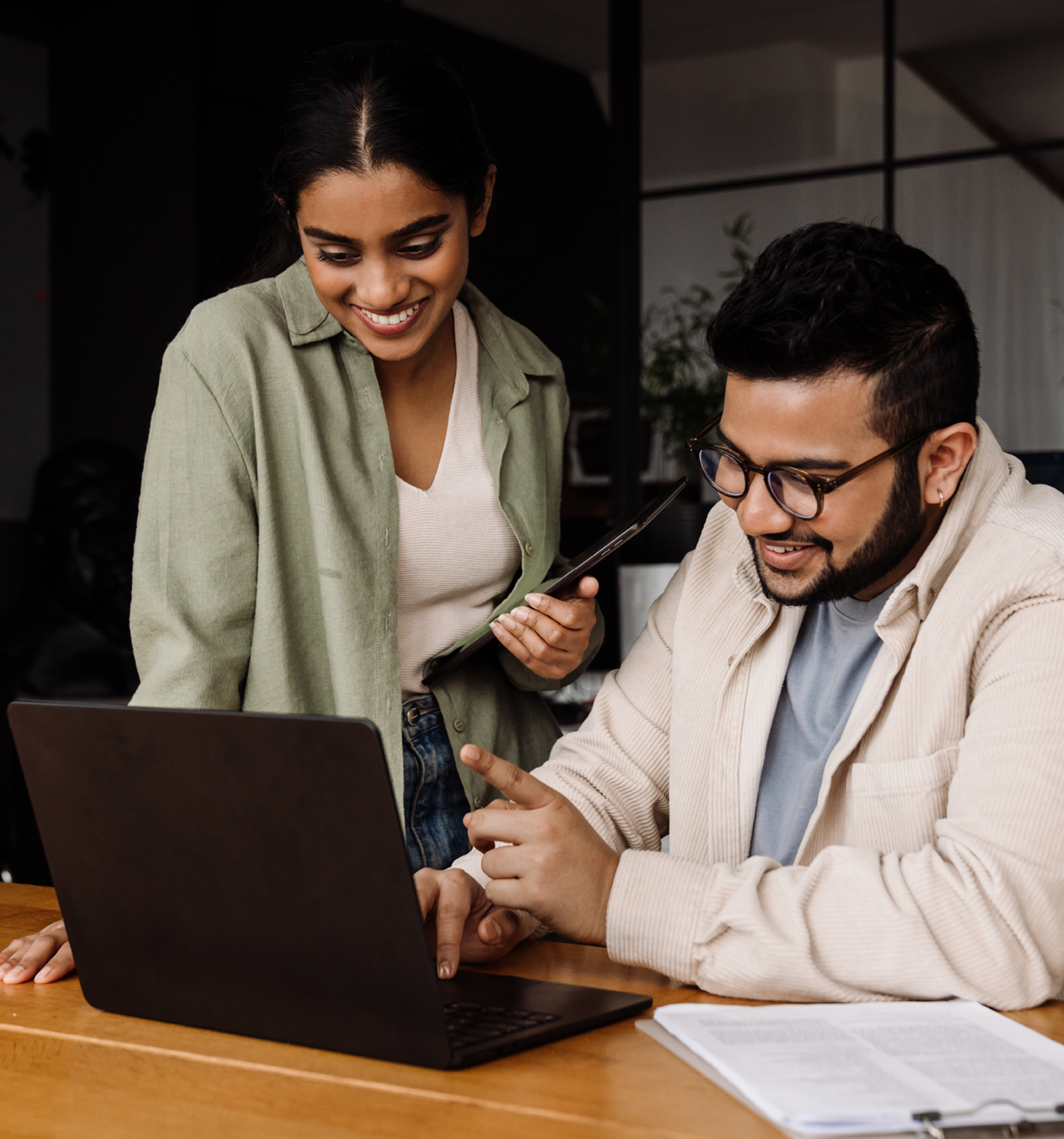 Two People Looking at a Computer and Smiling