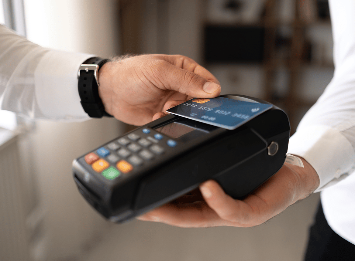 Close Up of Person Tapping Their Credit Card on Machine Reader