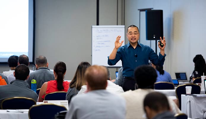 Frank Kim Wearing a Blue Shirt and Teaching In Classroom