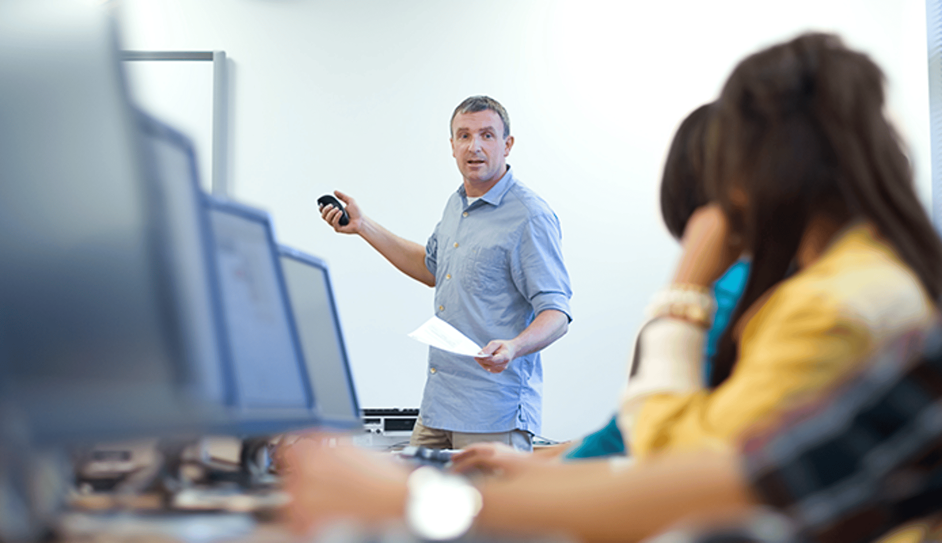 Instructor Using Smartboard Remote in Classroom